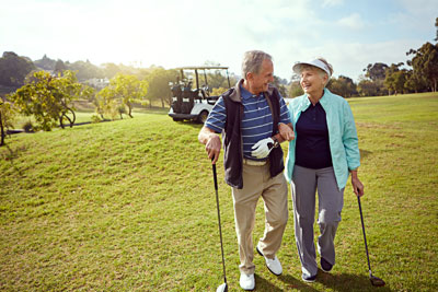 Elderly couple enjoying a casual walk on the golf course.