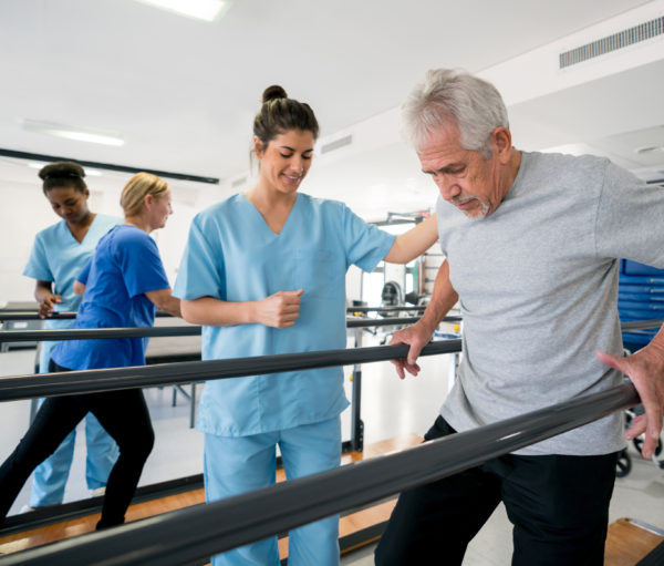 physical therapist working with elderly male patient